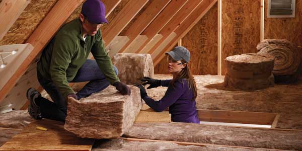 A man and Women insulating Attic